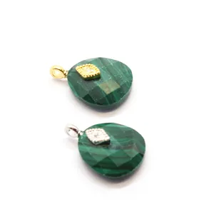 Detailed view of green faceted crystal pendants with evil eye gold accents.