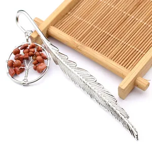 Detalle de un marcapáginas de pluma plateada con colgante del Árbol de la Vida de piedras naturales