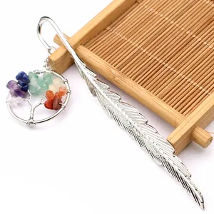 Detalle de marcapáginas de pluma plateada con colgante de Árbol de la Vida y gemas