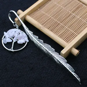 Detalle de marcapáginas metálico de pluma con árbol de la vida de cristal rosa