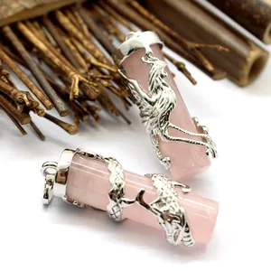 Detailed view of rose quartz pillar pendants with intricate silver dragon and phoenix carvings.