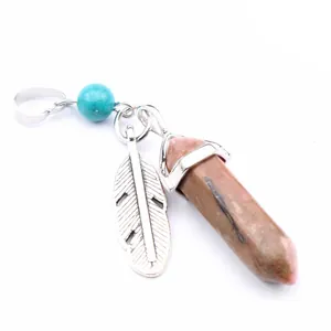 Detail view of a hexagonal crystal pendant with silver feather charm and turquoise bead.