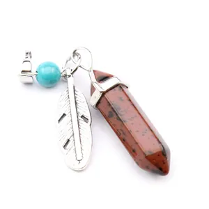 Detail view of hexagonal crystal pillar pendant with silver feather and turquoise bead.