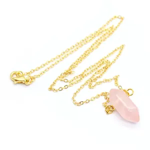 Detailopname van de roze kristallen zeshoekige hanger aan een goudkleurige ketting
