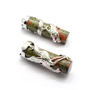 Macro detail of dragon and phoenix carvings on unakite stone cylinder pendants