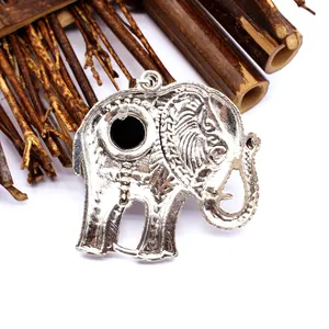 Gedetailleerd achteraanzicht van een vintage zilveren olifant hanger op bamboe stokken