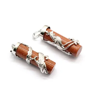 Detailed close-up view of dragon and phoenix goldstone pillar pendants with silver metal wrap.