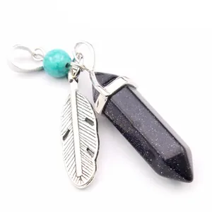 Detail view of a hexagonal blue sandstone crystal pendant with a feather and turquoise charm.