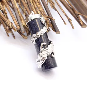 Macro view of detailed silver dragon engraving on a blue goldstone column pendant.