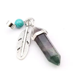 Close-up of hexagonal fluorite crystal pendant with silver feather and turquoise bead.