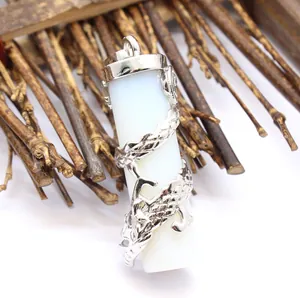 Detailed macro view of a silver dragon sculpture wrapped around a white stone pillar pendant.