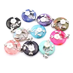 Collection of various stone donut pendants featuring white shell flowers and silver leaf motifs
