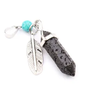 Detailed view of a hexagonal lava stone pendant with a metal feather and turquoise bead charm.