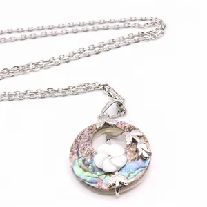 Elegant vintage-style circular shell pendant necklace featuring a carved white flower