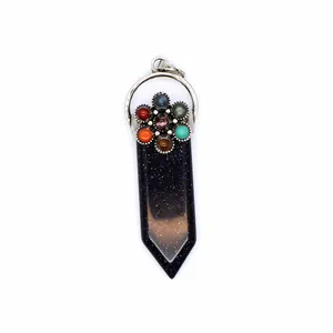 Detalle de un colgante de espada de piedra arenisca azul 7 chakra con gemas de colores