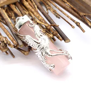 Macro detail of pink crystal pillar pendant with silver dragon carving on wood sticks