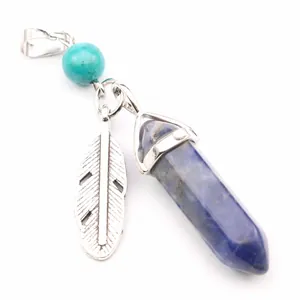 Macro detail of hexagonal crystal pillar pendant with silver feather and turquoise bead