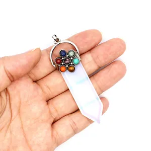 Primer plano de un colgante hexagonal de piedra blanca con diseño de flor de 7 chakras.