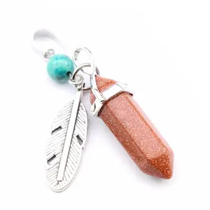 Detailed view of bohemian hexagonal goldstone pendant with feather charm and bead.