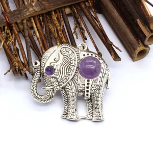 Macro-opname van een antieke zilveren olifant hanger met paarse steen en patronen.