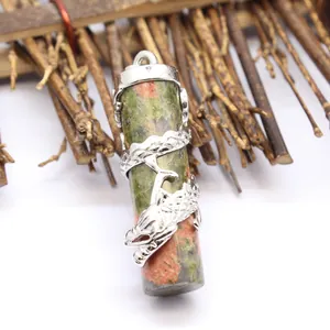 Close-up detail of ethnic Unakite stone pillar pendant with silver dragon sculpture