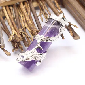 Close-up of amethyst crystal pillar pendant with silver dragon wrap detail on wood.