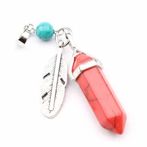 Detail shot of red hexagonal crystal pillar pendant with silver feather and turquoise bead
