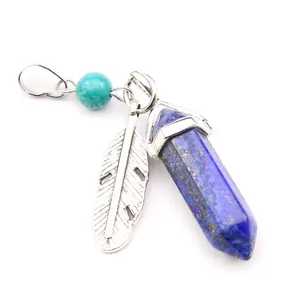 Detailed view of blue hexagonal crystal pillar pendant with silver feather and turquoise bead