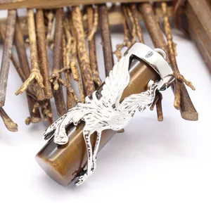 Close-up of intricate dragon and phoenix carving on cylindrical crystal stone pendant