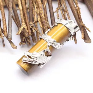 Macro detail of silver dragon wrapped around chatoyant tiger eye stone pillar pendant