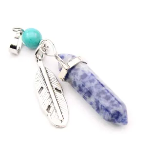 Close-up of hexagonal blue crystal pendant with silver feather and turquoise bead charm