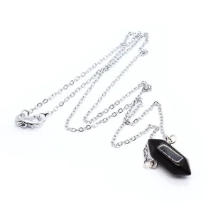 Detailweergave van een zwarte zeshoekige kristallen hanger aan een zilveren ketting