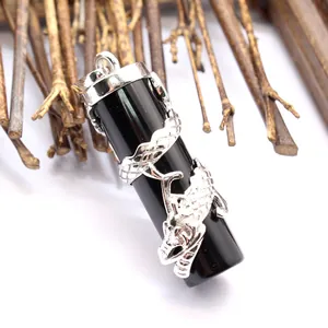 Detailed macro view of black cylindrical stone pendant wrapped in silver dragon sculpture