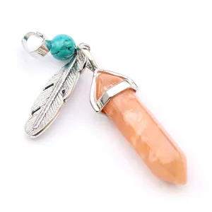 Macro view of hexagonal orange agate pendant with silver feather and turquoise bead