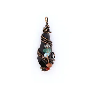 Detailed close-up of a black faceted crystal pendant wrapped in vintage copper wire.