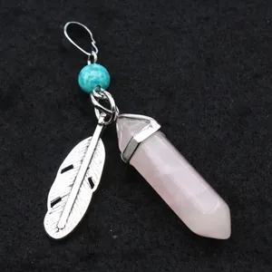 Detail view of pink hexagonal crystal pendant with silver feather and turquoise bead