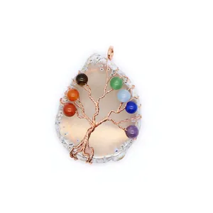 Detailweergave van handgemaakte levensboom hanger met chakra kralen op agaat schijf.