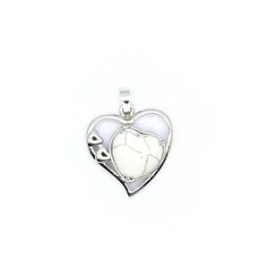 Vue détaillée d'un pendentif en forme de cœur en argent avec une pierre howlite au centre.