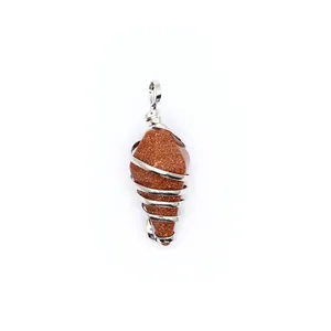 Detailed macro view of a handcrafted wire-wrapped gold sandstone hexagonal cone pendant