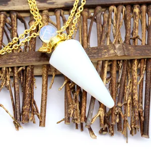 Close-up of white crystal cone perfume bottle pendant with gold chain on bamboo background