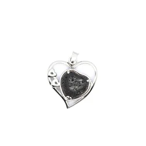Détail macro d'un pendentif en forme de cœur en argent avec une pierre de lave noire