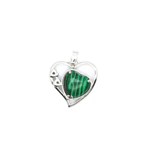 Détail d'un pendentif en argent en forme de cœur avec une pierre verte striée élégante