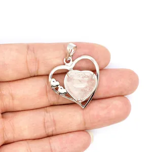 Vue détaillée d'un pendentif cœur argenté avec une pierre précieuse translucide