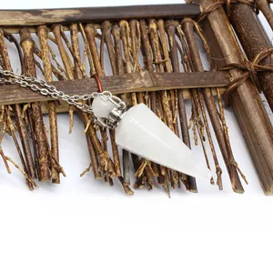 Close-up detail of white crystal cone pendant perfume bottle on natural bamboo mat background