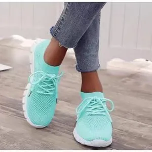 Stilvolle türkisfarbene atmungsaktive Fly-Knit-Sneaker für Damen am Fuß getragen