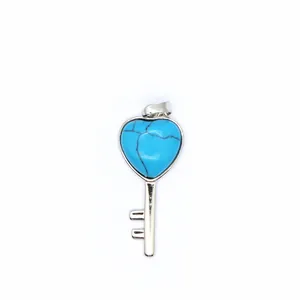Close-up detail of a vintage heart-shaped turquoise stone key pendant with silver finish