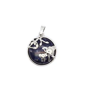 Vue détaillée d'un pendentif éléphant en argent avec mère et bébé sur pierre bleue.
