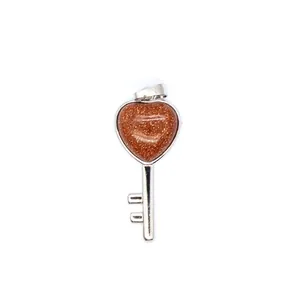 Macro detail of heart-shaped goldstone key pendant with sparkling silver finish