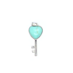 Detailed macro view of heart-shaped turquoise gemstone set in a silver key pendant