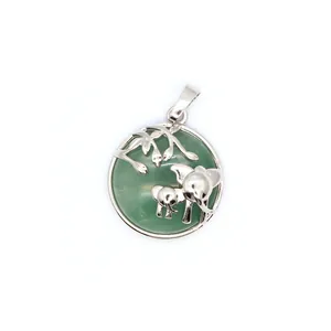 Vue macro d'un pendentif famille éléphants argenté sur une base circulaire en pierre verte